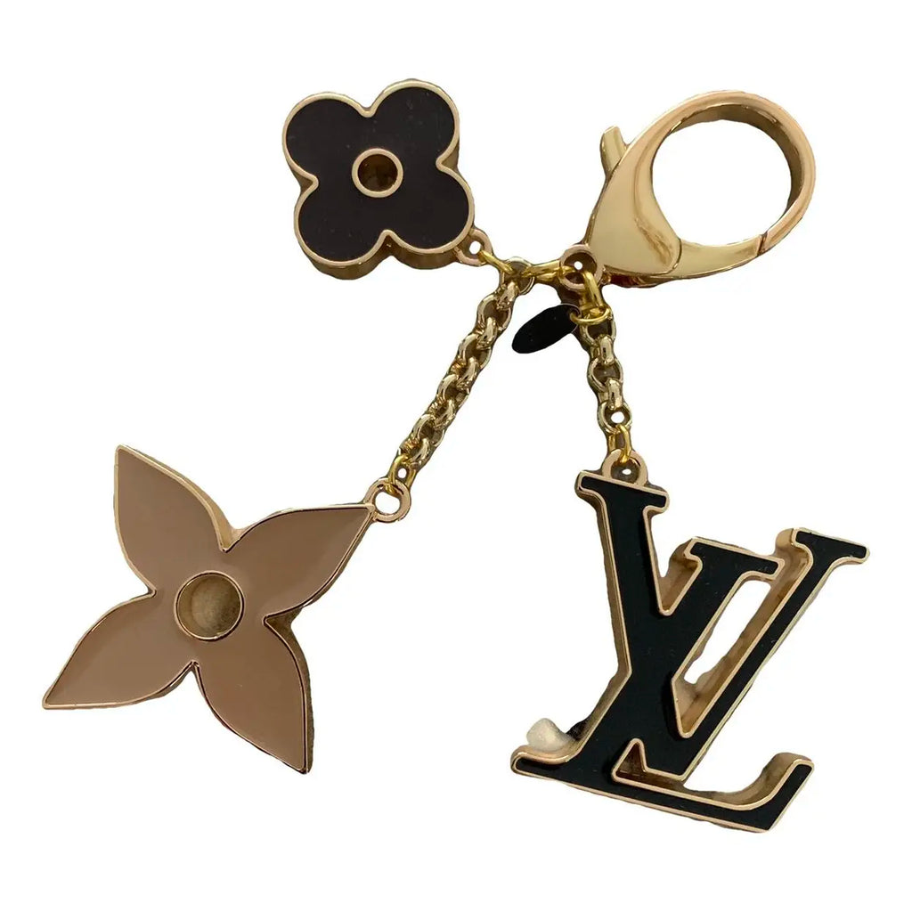 a keychain with black and gold charms on a white background