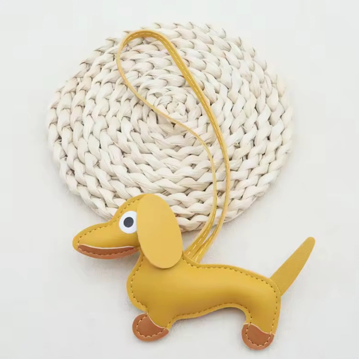 Yellow dachshund-shaped keychain on a white background